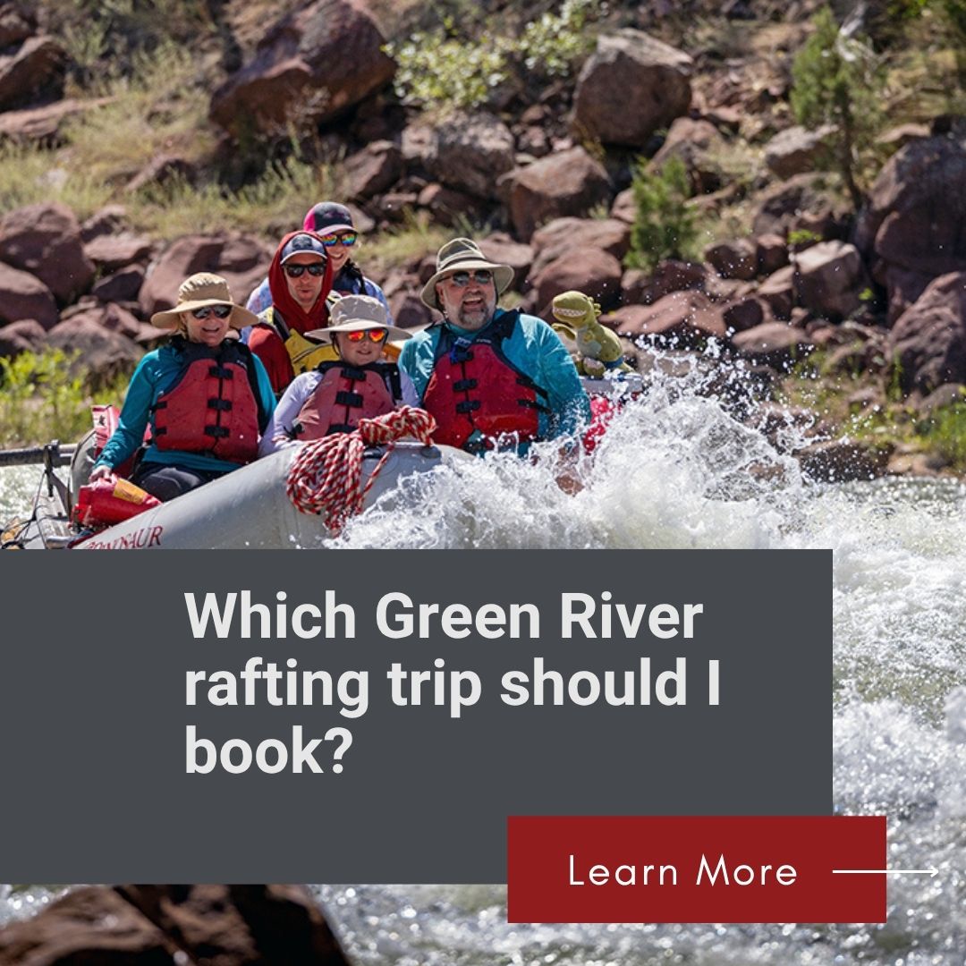 Rafters on a Green River rafting trip through red canyon walls